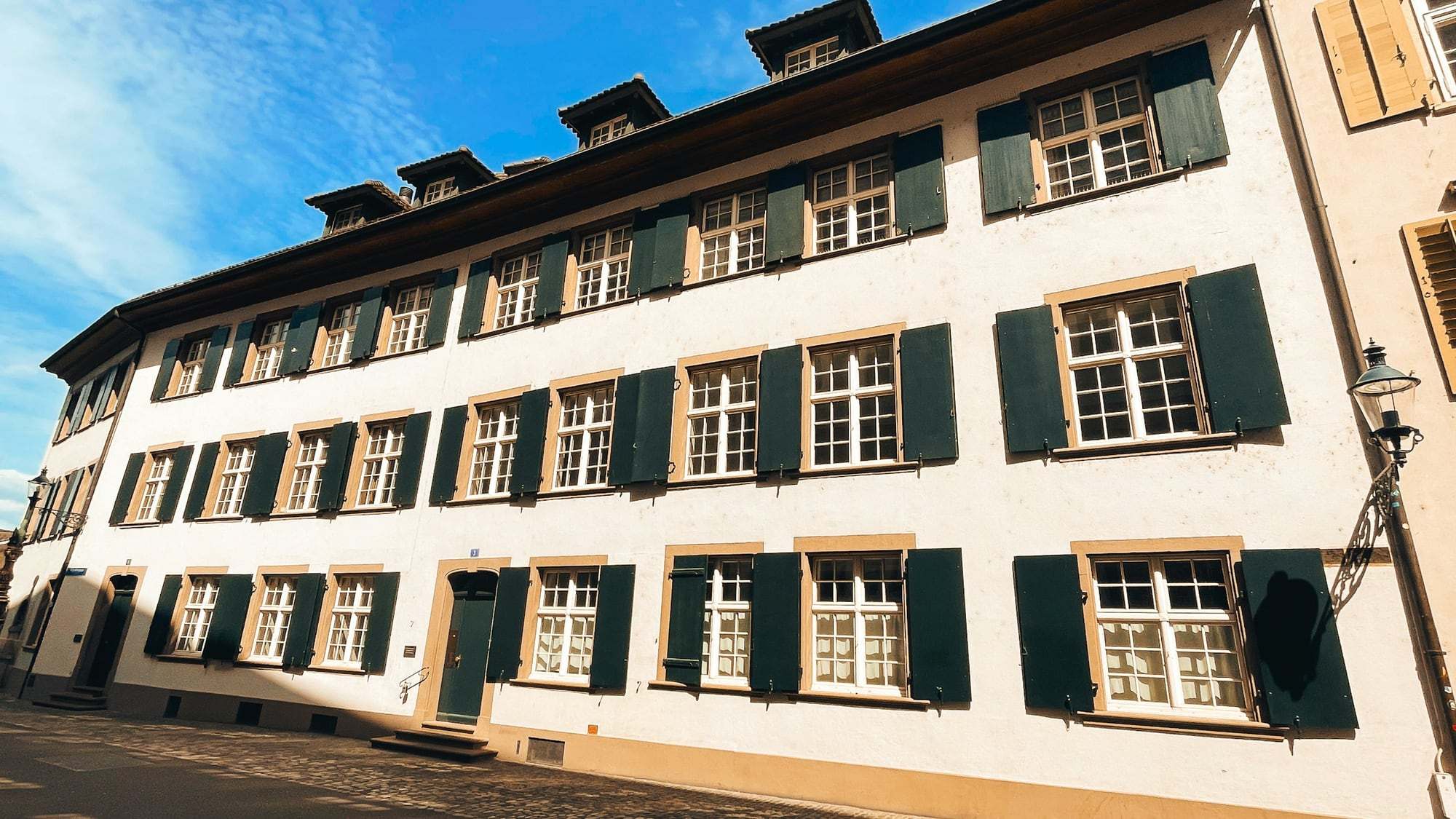 Fassade eines Altbaus mit Fensterläden und Dachgauben