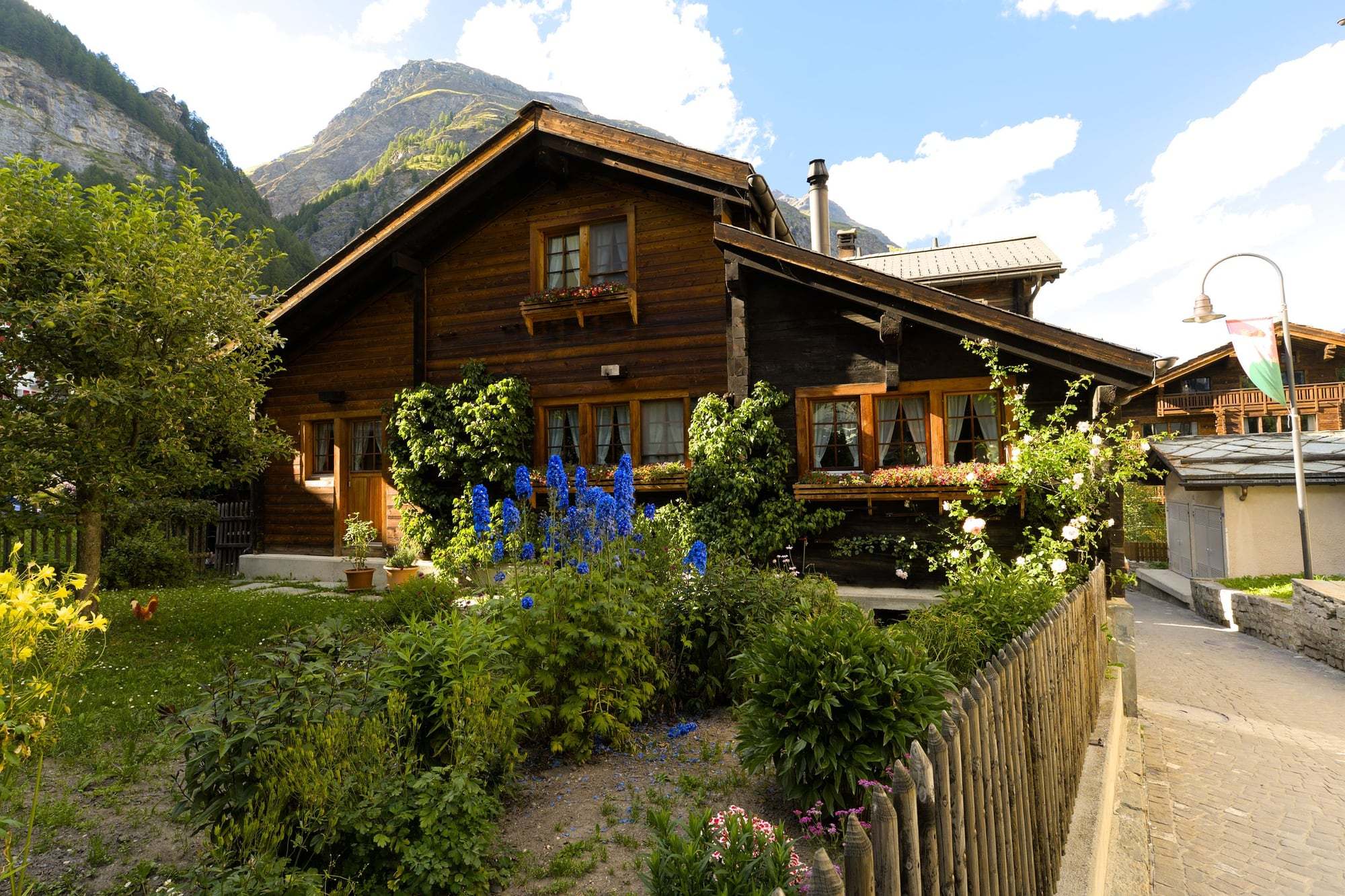 Holzhaus mit Blumengarten und Dachvorsprung